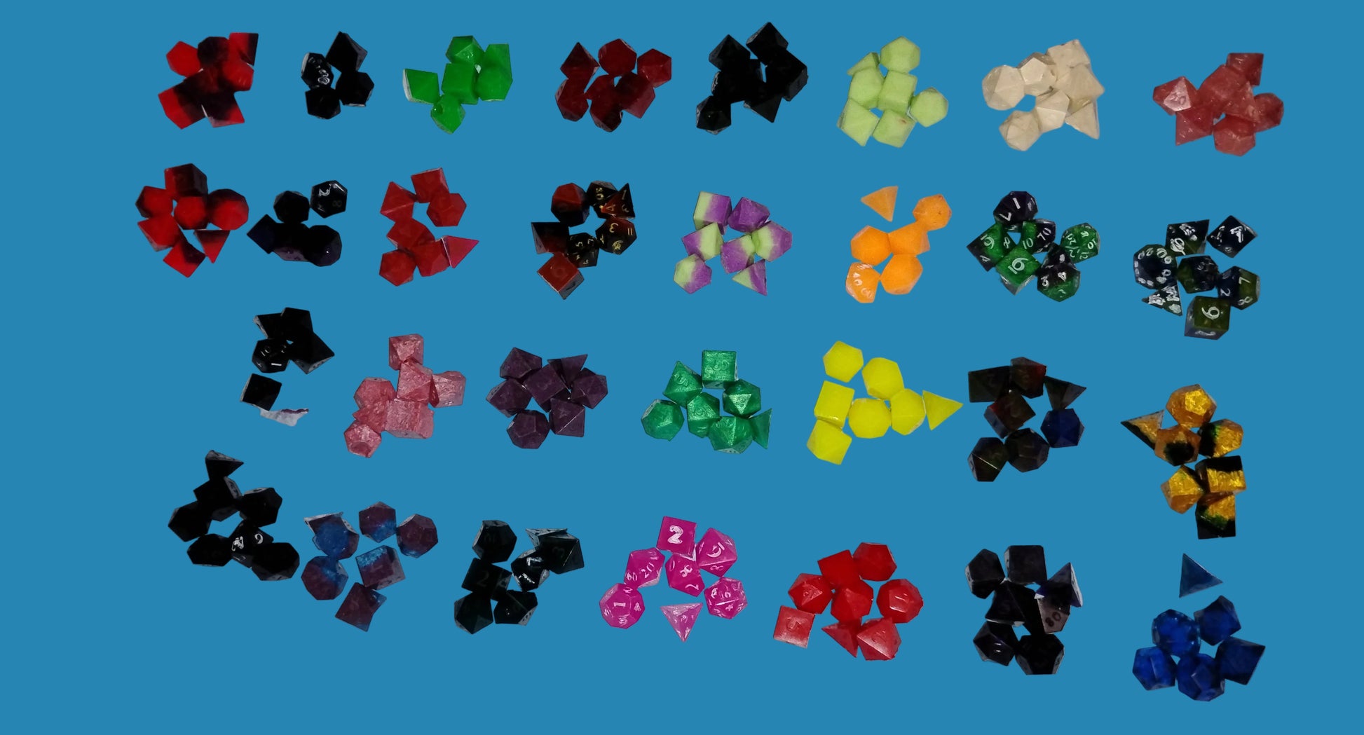 A collection of colorful polyhedral gaming dice arranged in rows on a white fabric background.