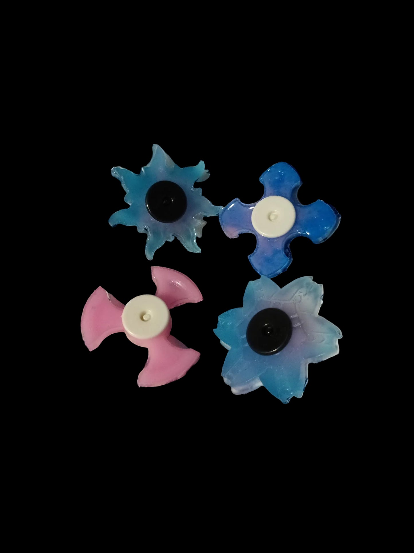 Three colorful flower-shaped objects on a striped fabric background