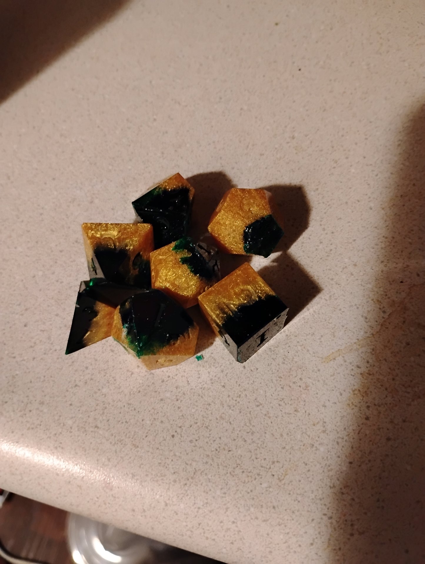 Stack of black and gold square-shaped objects on a beige surface