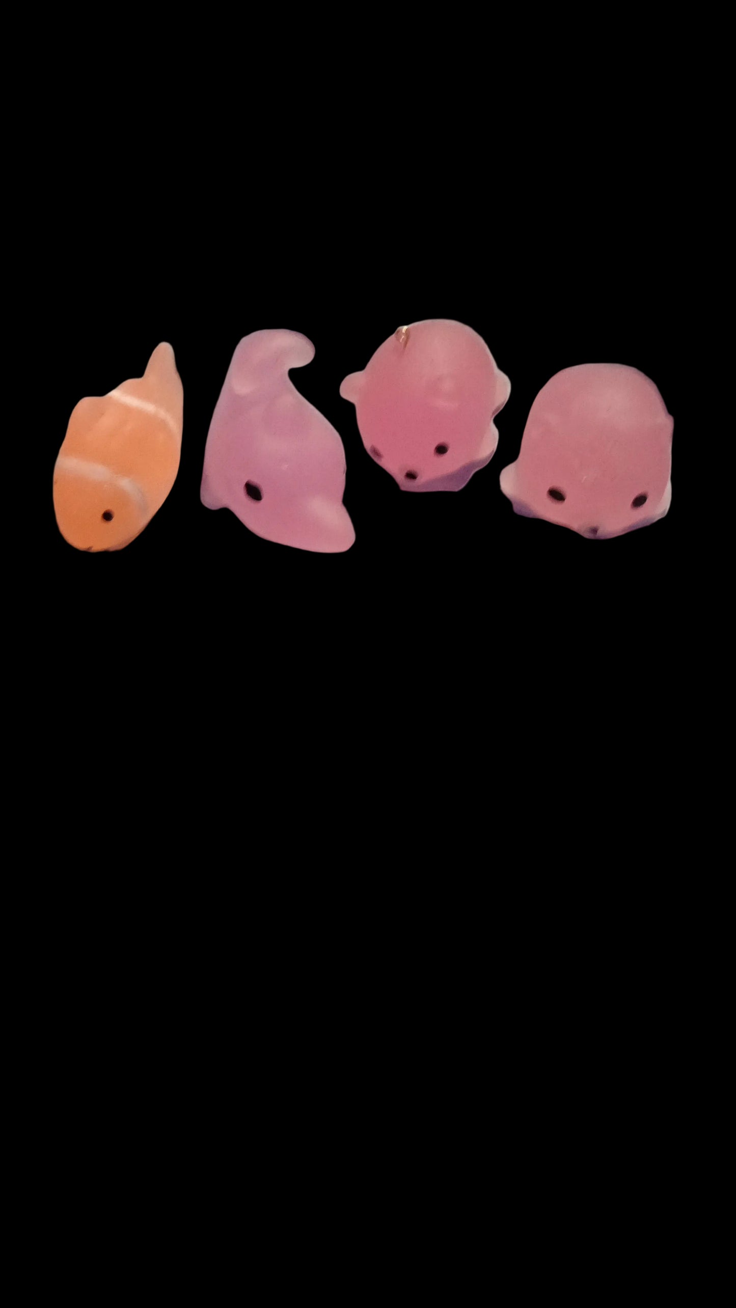 Pink and orange fish-shaped clips on a white fabric background